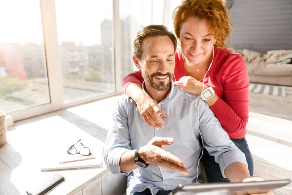 A couple looking at a tablet computer in their home.