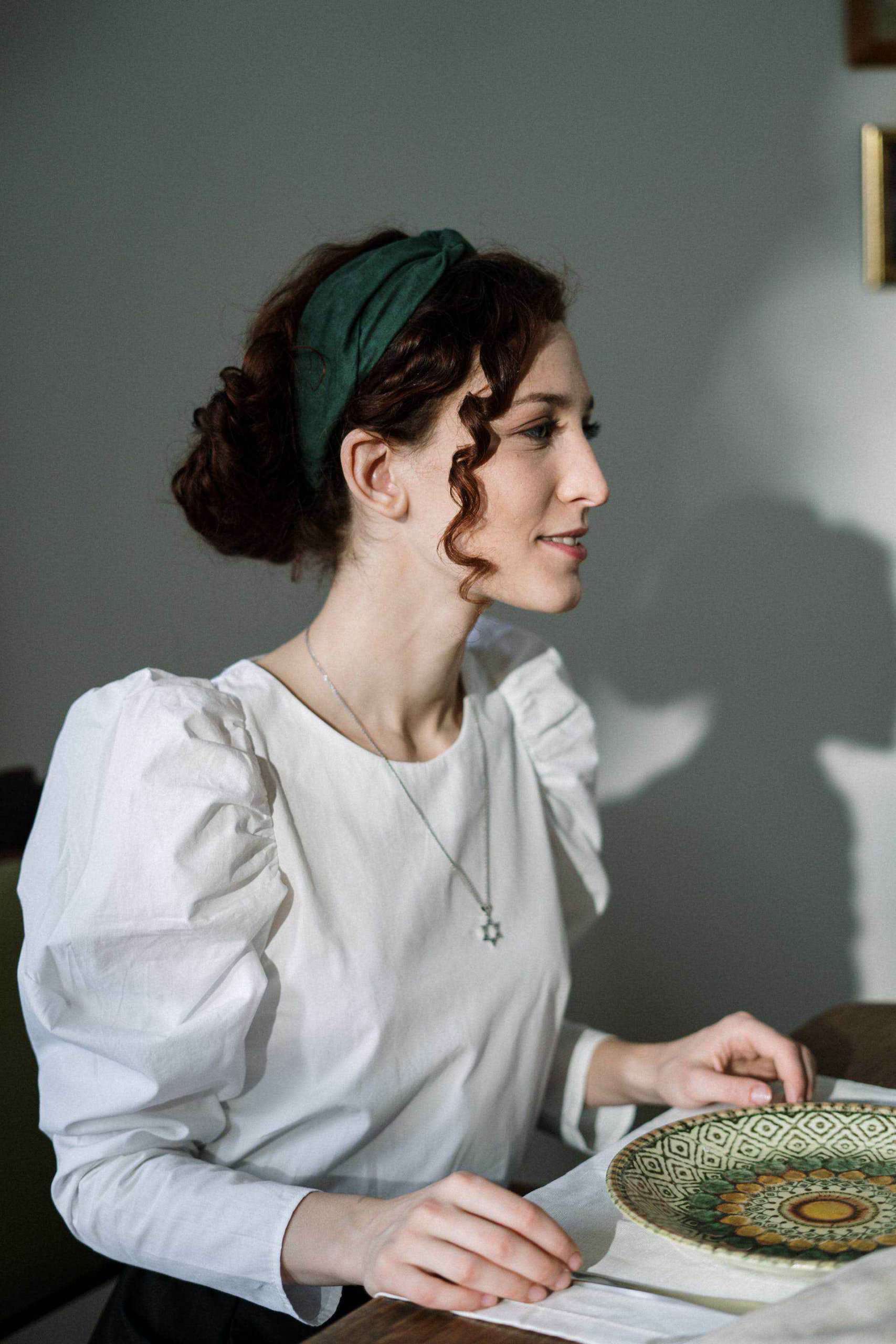 A woman sitting at a table with a plate in front of her.